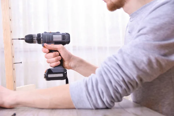 Man is working with furniture assembly using electric screwdriver in new house installation - technician onsite work using hand tools concept — Stock Photo, Image