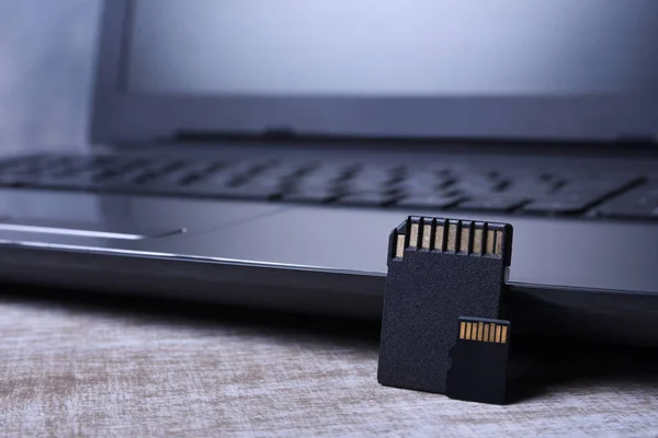 Micro SD minneskort adapter på laptop bakgrund på träbordet. närbild — Stockfoto