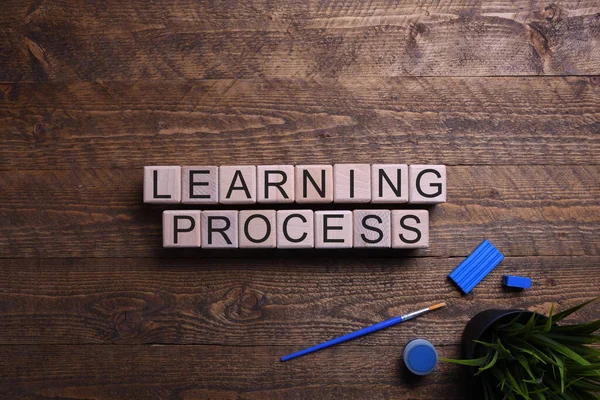 Word learning process wooden cubes, blocks on the subject of education, development and training on a wooden background. Top view. Place for text. — Stock Photo, Image