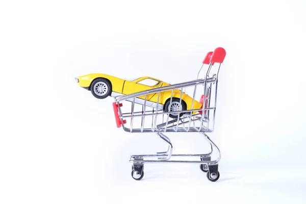 Concept van het kopen van een nieuwe auto. Speelgoedauto in mandje geïsoleerd op witte achtergrond — Stockfoto