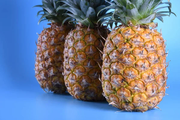 Tři zavřít ananas na modrém pozadí — Stock fotografie