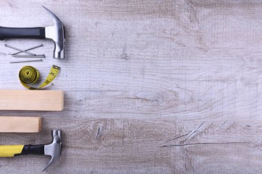 Çekiç demiri, santimetre bant ve tahta zeminde çiviler.