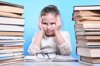 Okula geri dönen mutlu, çalışkan çocuk kapalı bir masada oturuyor. Çocuk sınıfta öğreniyor..