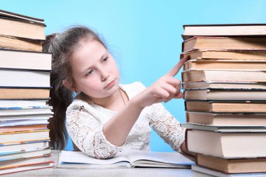 Okula geri dönen mutlu, çalışkan çocuk kapalı bir masada oturuyor. Çocuk sınıfta öğreniyor..