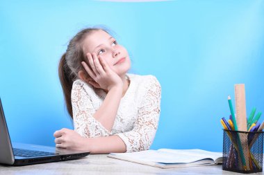 Okula geri dönen mutlu, çalışkan çocuk kapalı bir masada oturuyor. Çocuk sınıfta öğreniyor..