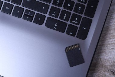 Tahta masadaki dizüstü bilgisayarda mikro SD hafıza kartı adaptörü. Kapat.