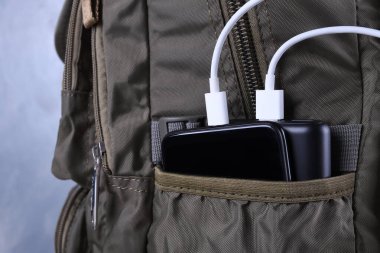Telefon şarjı, elektrik faturası akıllı telefon, enerji bankasıyla cep telefonu. Sırt çantasındaki Güç Bankası 'nın derinliği