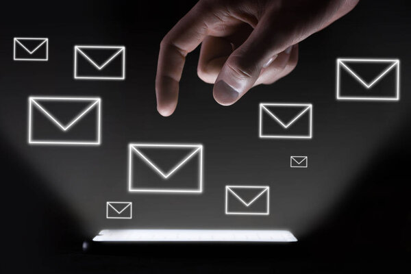 one Man's hand, finger stretches to the screen of the phone which glows on a dark background. Technology addiction concept.finger clicks to message icons