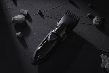 Üst Manzara. Koyu betonda saç ve kafa kesme makinesi, sert gölgeli taş arka plan.