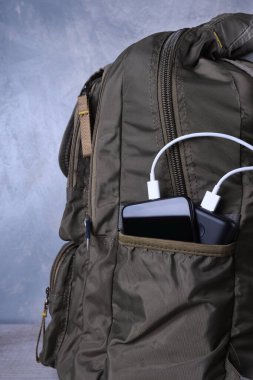 Telefon şarjı, elektrik faturası akıllı telefon, enerji bankasıyla cep telefonu. Sırt çantasındaki Güç Bankası 'nın derinliği