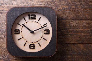 Ahşap arka planda el yapımı ahşap saat. Yakın plan. Bir metin için yer.