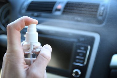 Arabanın içini temizlemek ve dezenfeksiyon sıvısı sıkmak. Direksiyon ve direksiyon kollarında dezenfeksiyon var. Coronavirus koruması. Virüs koruması. Vihicle içeriden dezenfekte ediliyor.