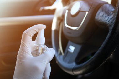 Arabanın içini temizlemek ve dezenfeksiyon sıvısı sıkmak. Direksiyon ve direksiyon kollarında dezenfeksiyon var. Coronavirus koruması. Virüs koruması. Vihicle içeriden dezenfekte ediliyor.