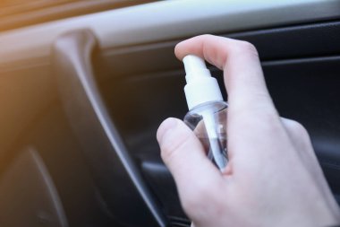 Arabanın içini temizlemek ve dezenfeksiyon sıvısı sıkmak. Direksiyon ve direksiyon kollarında dezenfeksiyon var. Coronavirus koruması. Virüs koruması. Vihicle içeriden dezenfekte ediliyor.