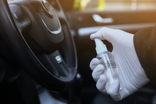 Arabanın içini temizlemek ve dezenfeksiyon sıvısı sıkmak. Direksiyon ve direksiyon kollarında dezenfeksiyon var. Coronavirus koruması. Virüs koruması. Vihicle içeriden dezenfekte ediliyor.