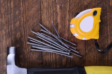 Çekiç demiri, santimetre bant ve tahta çiviler.