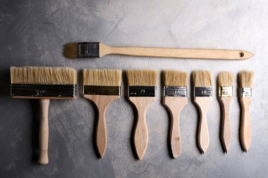 Gri beton arka planda boya fırçaları. Üst görünüm