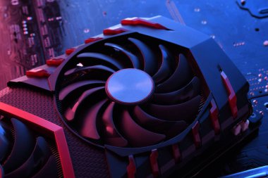 Bilgisayar oyunu grafikleri kartı, devre kartında iki soğutucu olan video oyunu, anakart geçmişi. Yakın plan. Kırmızı-mavi ışıkla.