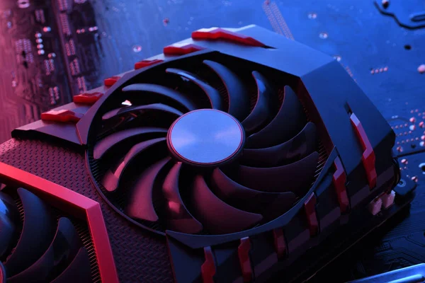 Computer game graphics card, videocard with two coolers on circuit board ,motherboard background. Close-up. With red-blue lighting.