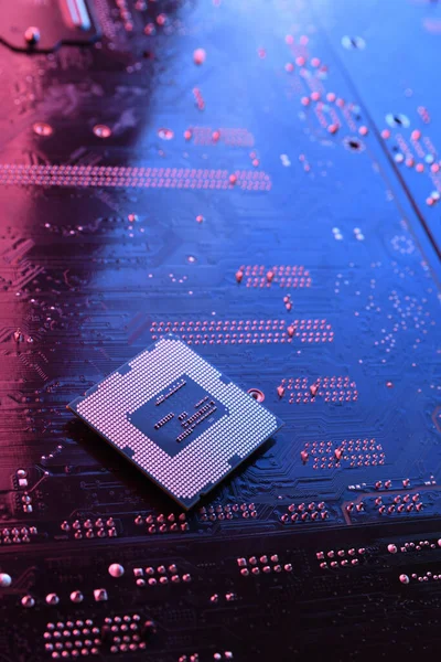 Computer cpu processor chip on circuit board ,motherboard background. Close-up. With red-blue lighting.
