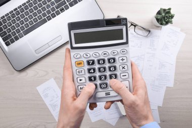 Masa başında hesap makinesi kullanan tanınmayan bir işadamı. Ofisteki maliyeti hesaplayarak not alın. Finans muhasebe kavramı. vergi, alışveriş, maliyet yönetimi.