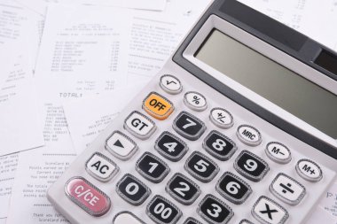 Ahşap bir arka planda, mağazadan gelen bir yığın çeke güvendiğin için hesap makinesi. Üst Manzara. Metin için yer. Boşluğu kopyala.