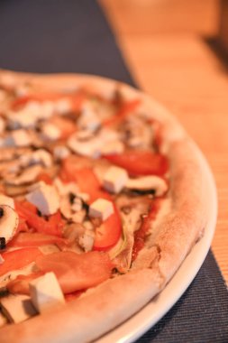 Kafedeki masada vejetaryen pizza. Mavi arkaplan ile yakın plan