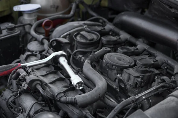 stock image The ratchet wrench with the nozzle head rests on the car engine. A Car repair