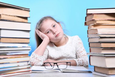 Okula dönüyorum. Mutlu, çalışkan çocuk içeride bir masada oturuyor. Çocuk derste öğreniyor. Dağlar dolusu kitap.