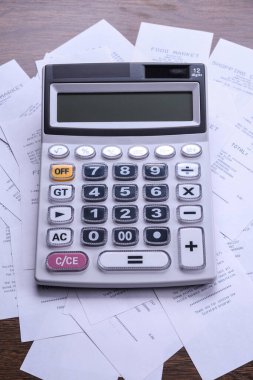 Ahşap zemin üzerinde mağazadan alınmış çeklerle hesaplayıcı tuş takımı. Üst Manzara. Boşluğu kopyala