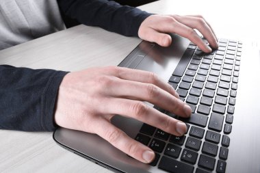 Bir erkeğin dizüstü bilgisayarında klavyeye yakın çekim