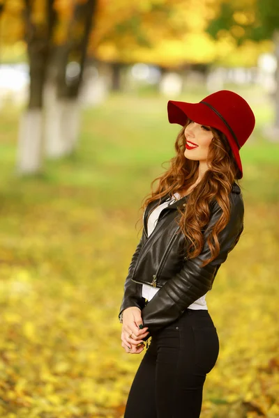 Schöne elegante Frau mit modischem roten Hut im Herbst in einem Park. — Stockfoto