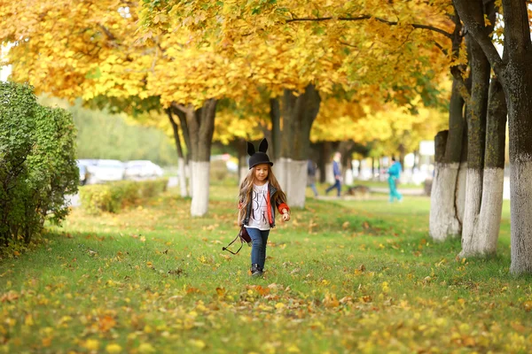 Stilvolles kleines Mädchen geht im Wald spazieren. — Stockfoto