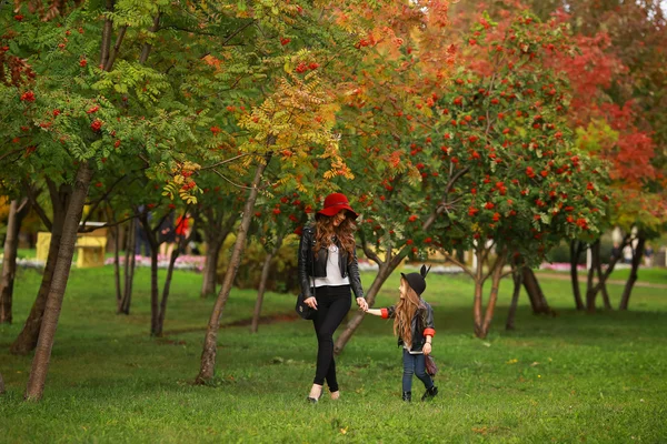 Madre e figlia che camminano tenendosi per mano al parco. Stile di vita familiare concetto . — Foto Stock