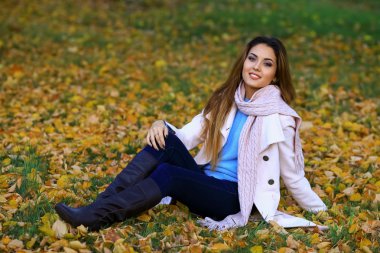 Genç kadın gülümseyerek ve sonbaharda sarı akçaağaç Bahçe arka plan. boş alan