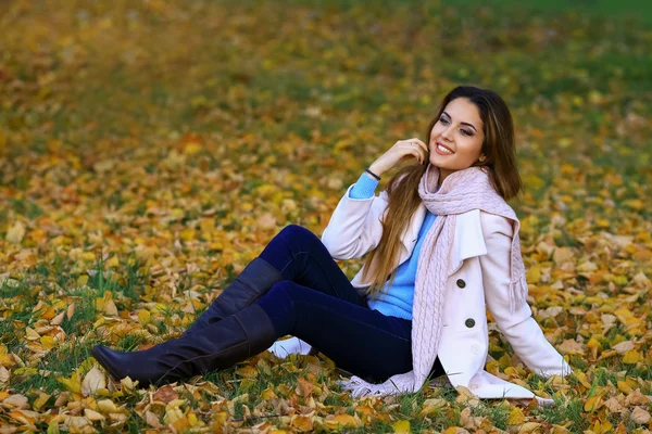 Wanita muda tersenyum dan jatuh kuning maple taman latar belakang. ruang kosong — Stok Foto