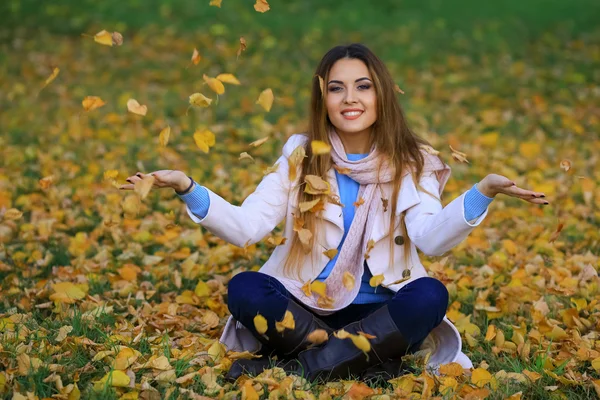 Frau wirft Herbstblätter in die Luft — Stockfoto