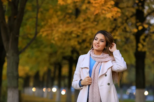 Giovane donna sorridente all'aperto e autunno giallo giardino sfondo . — Foto Stock