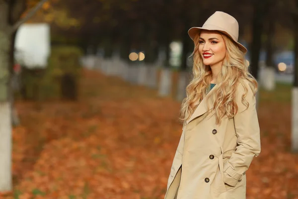 Mulher elegante bonita de pé em chapéu bege na moda em um parque no outono. espaço livre . — Fotografia de Stock