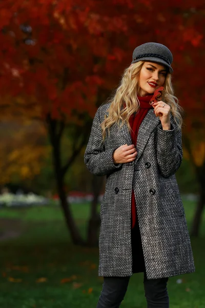 Porträt einer fröhlichen jungen Frau, die mit Herbstblättern steht — Stockfoto