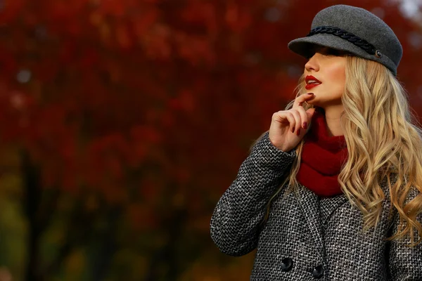 Schöne Frau im Herbst Park. roter Ahorn Garten Hintergrund. Blick nach links vom Rahmen zum leeren Kopierraum. — Stockfoto