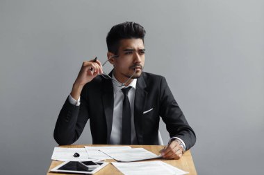 kamera, tablet, telefon ve kağıtları uzak tablo üzerinde seyir gözlüklü başarılı adam.