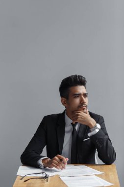 kamera, tablet, telefon ve kağıtları uzak tablo üzerinde görünen başarılı adam.