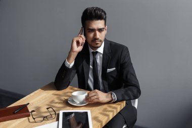 Genç dalgın işadamı bir kafede kahve konuşmak