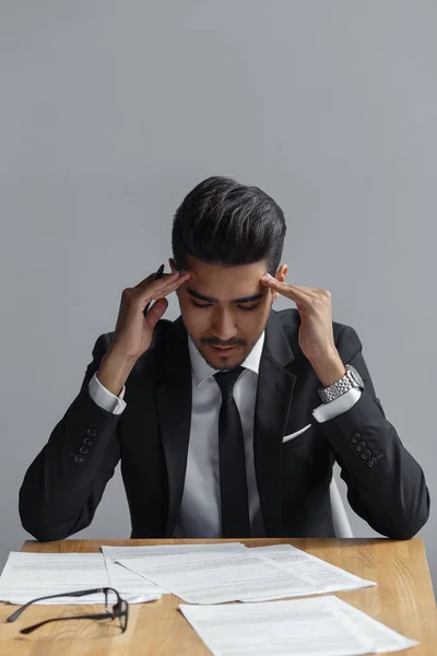 Empresário deprimido sentado à mesa com documentos — Fotografia de Stock