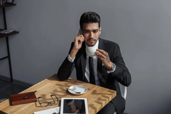 Nachdenklicher Geschäftsmann plaudert und trinkt Kaffee im Café — Stockfoto