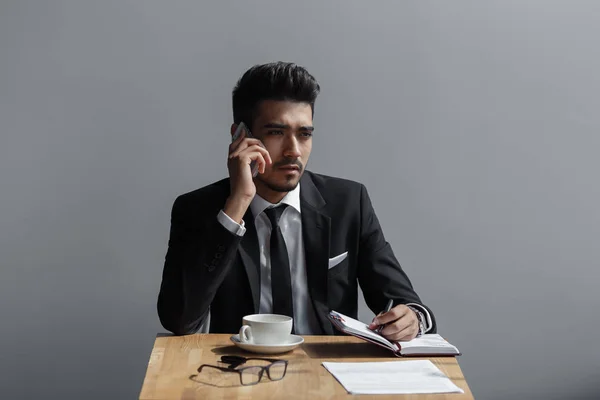 Een mooie succesvolle man praten over de telefoon kantoor in café — Stockfoto