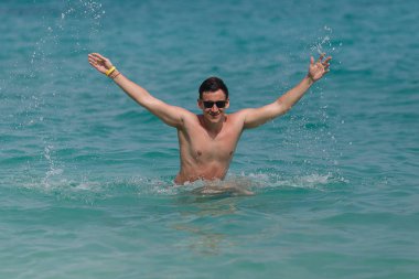 adam eğlence mavi denize kadar atlama ve spashing su var