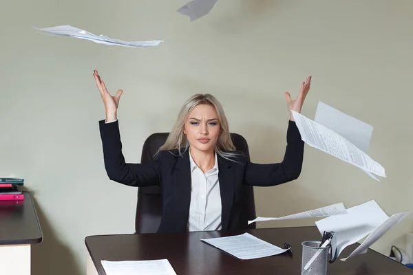 Junge Geschäftsfrau wirft Papierblätter in ihr Büro — Stockfoto