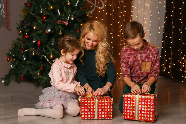 Glücklich aufgeregte Eltern schauen, wie Tochter Weihnachtsgeschenk öffnet. — Stockfoto